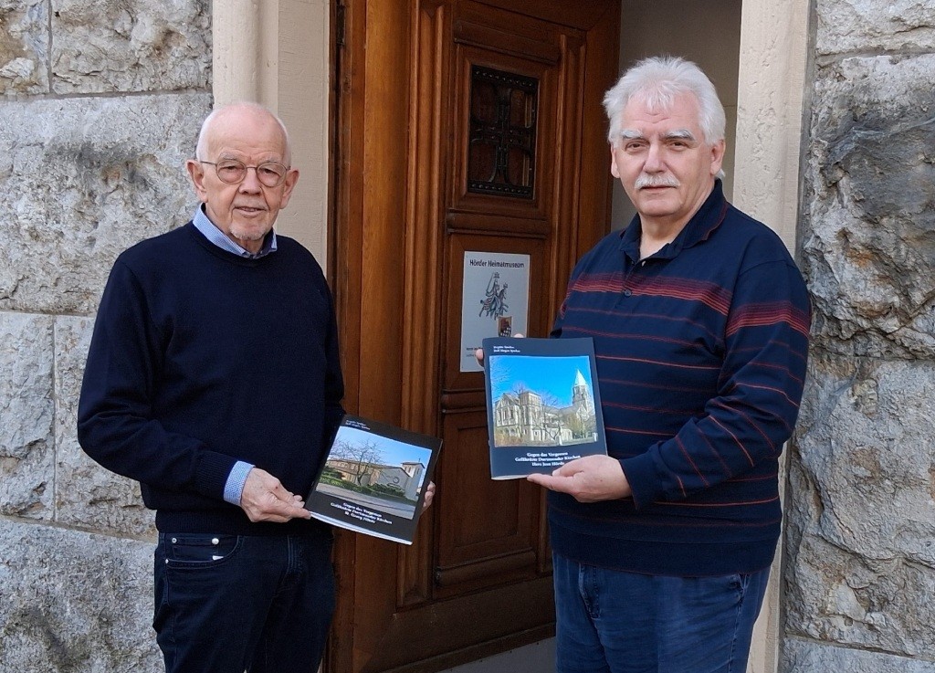 Bernhard Finkeldei (l.) und Raimund Schroeder stellen die neuen Broschüren zu den Kirchen St. Georg und Herz-Jesu vor. Foto: Heimatverein